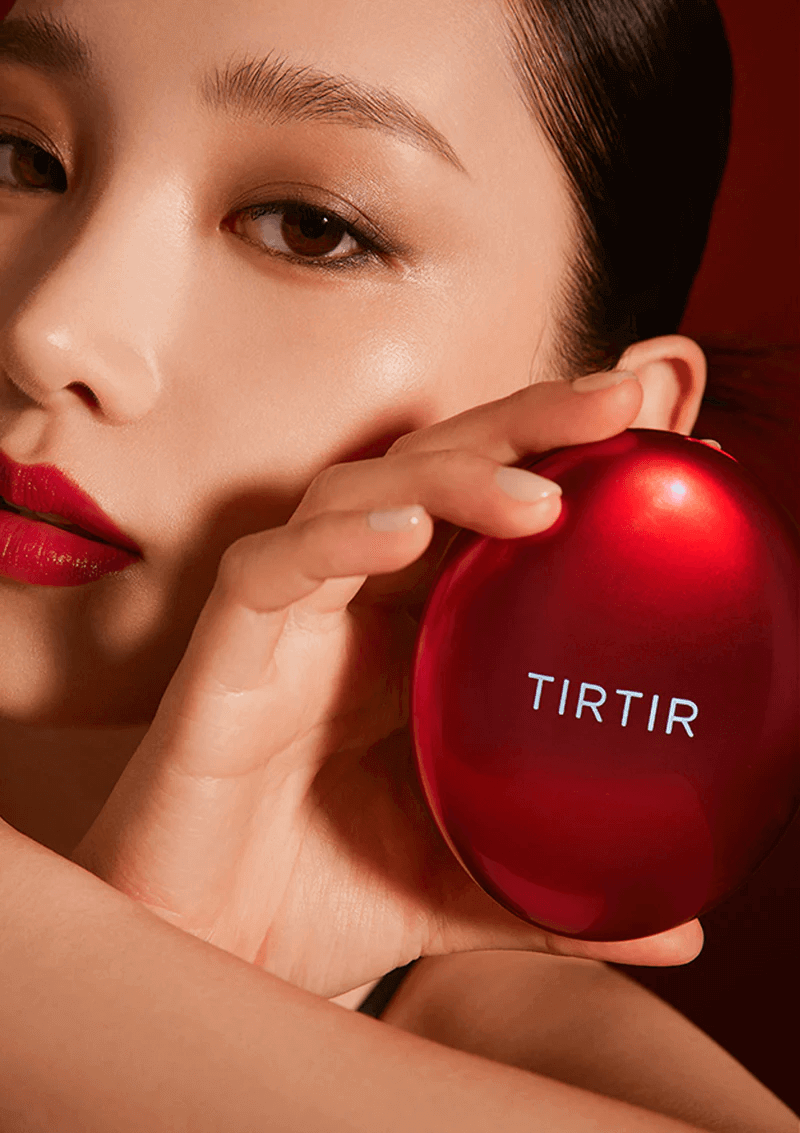 immagine suggestiva di ragazza asiatica che tiene nella mano e accanto al viso il cushion di tir tir di colore rosso